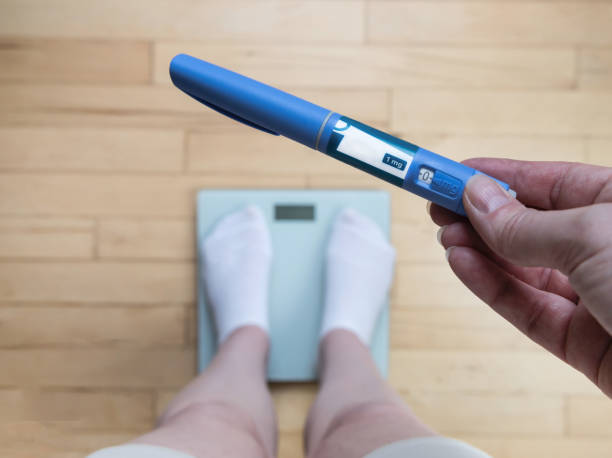 Ozempic Insulin injection pen for diabetics and weight loss. Woman weighs herself and holds Ozempic in her hand. Weight loss concept. Ozempic vs Semaglutide