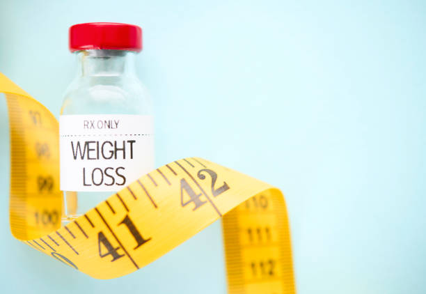 Insurance: Vial with weight loss medication on a blue background with a tape measure